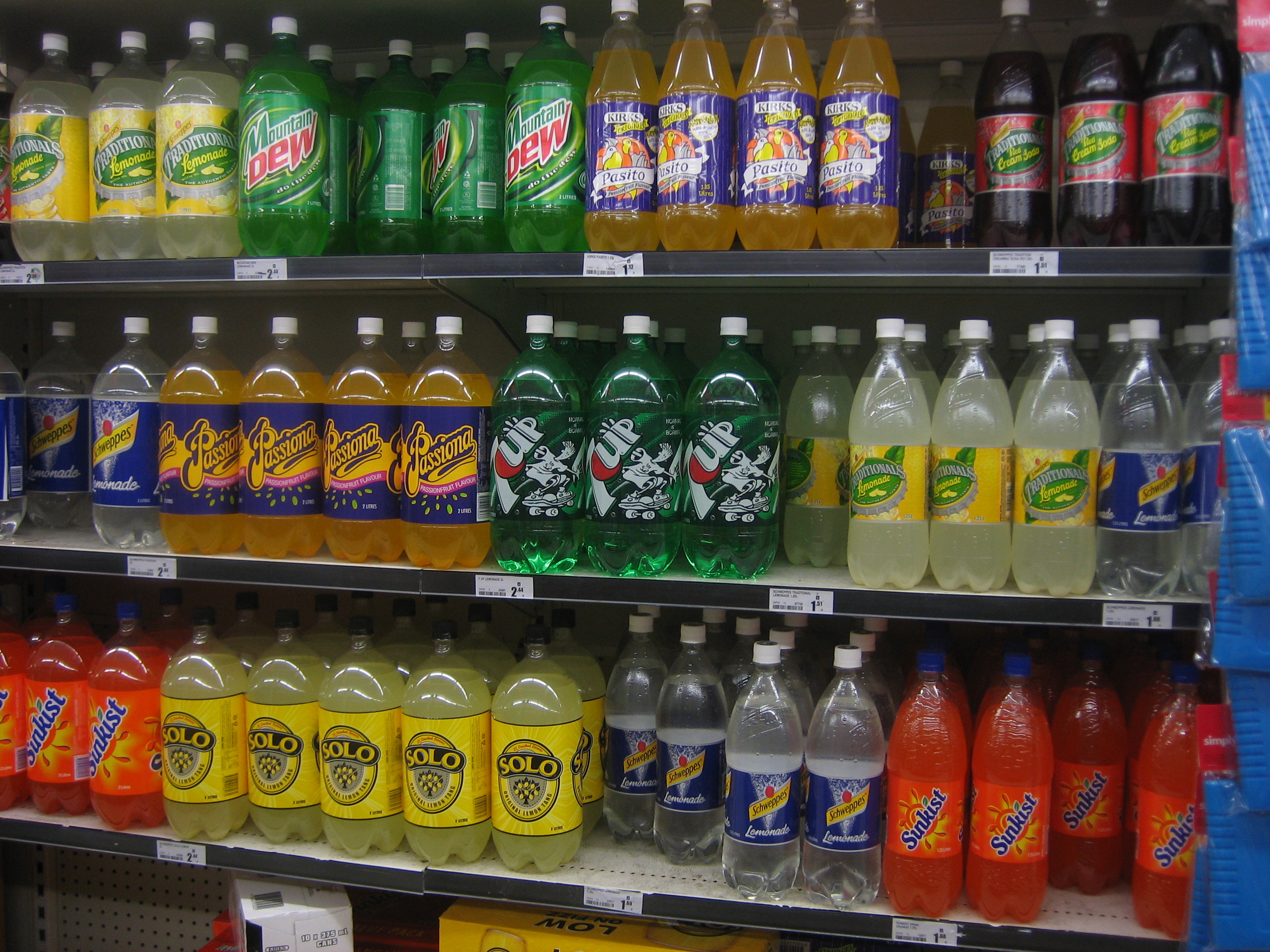 Botol minuman tersusun di rak toko